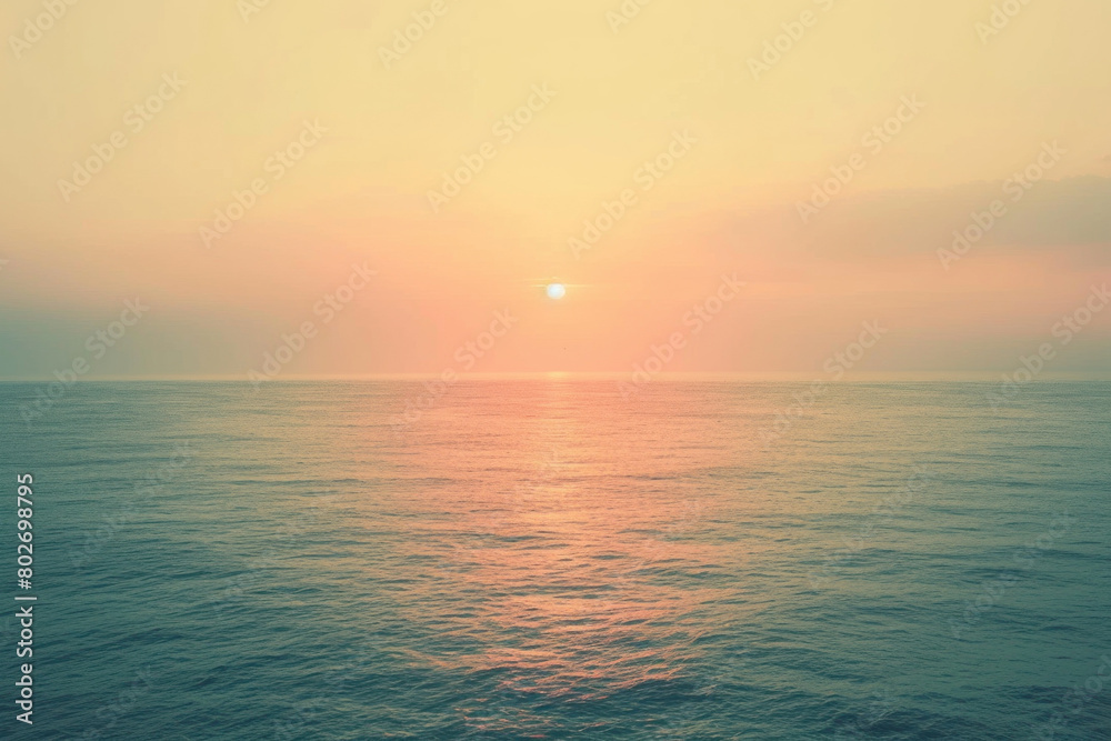 Tranquil sunset over the ocean with soft pink and orange hues reflecting on calm waters, inviting a peaceful end to the day.