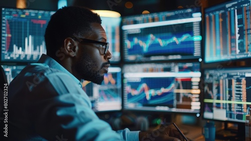 African American financial analyst reviewing live data streams on multiple screens