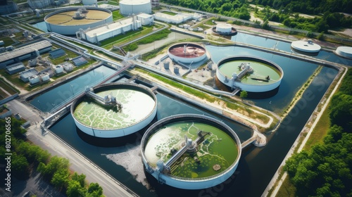 Aerial view of a large wastewater treatment facility, with visible circular tanks and aeration ponds,