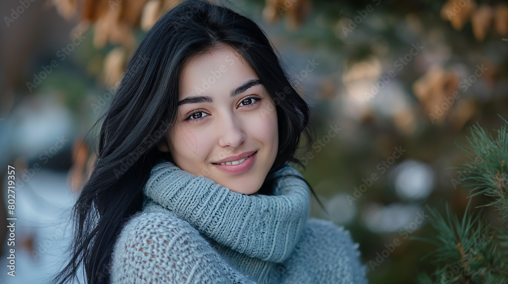 A smiling woman wearing a cozy sweater is captured in an outdoor winter environment A smiling woman wearing a cozy sweater is captured in an outdoor winter environment