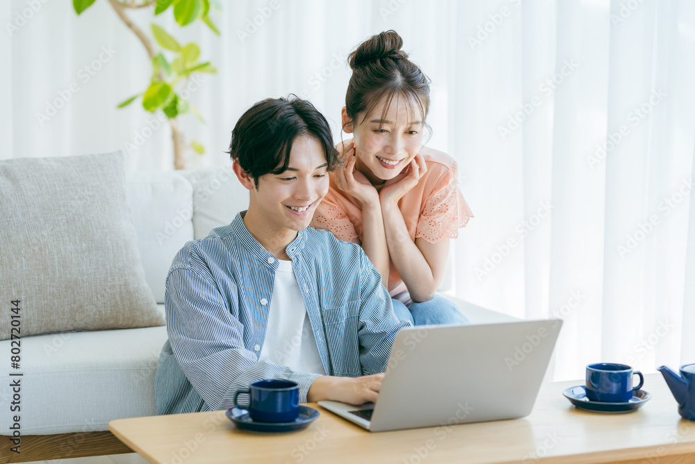 パソコンを見る若いカップル パソコンを見る若いカップル