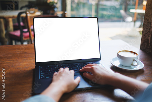 Mockup image of a woman working and typing on laptop computer with blank white desktop screen