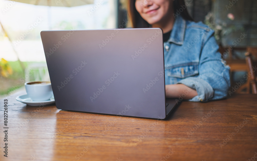 Closeup image of a young woman working and typing on laptop computer in cafe Closeup image of a young woman working and typing on laptop computer in cafe