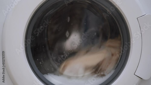 Washing machine washing clothes. Washing clothes with laundry detergent. Washing machine in the process of working
