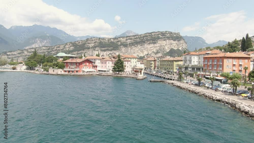 Aerial view of lake promenade in Torbole on Lake Garda with cars on the road on the lake on a sunny day Aerial view of lake promenade in Torbole on Lake Garda with cars on the road on the lake on a sunny day