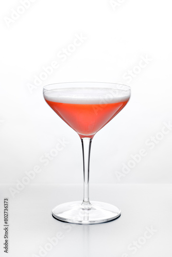 a pink cocktail in a coupe glass on white background stock images