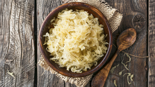 Plate and spoon with tasty sauerkraut on wooden background