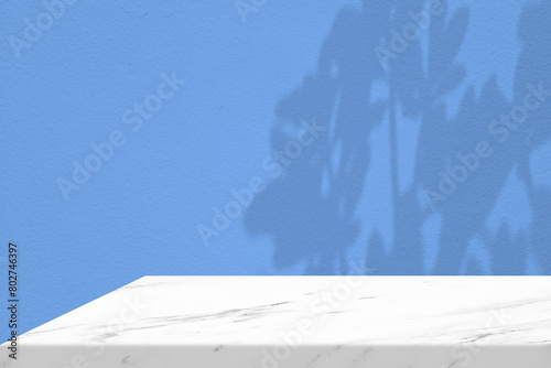 White Marble Table Corner with Light Beam, Shadow, and Spotlight on the Blue Concrete Wall Background