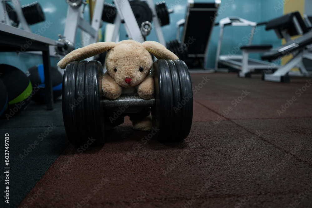 The hare athlete lifts dumbbells in the gym