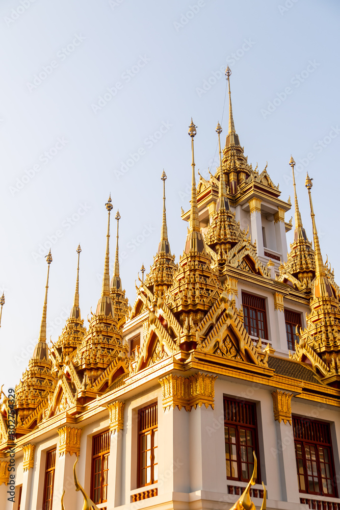 Fototapeta premium golden spires reaching toward the sky on buddhist temple in bangkok thailand