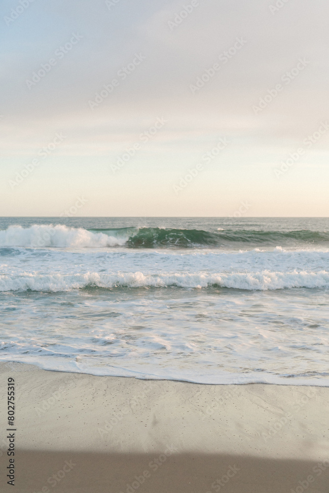 Gentle waves caress the beach at peaceful dusk Gentle waves caress the beach at peaceful dusk