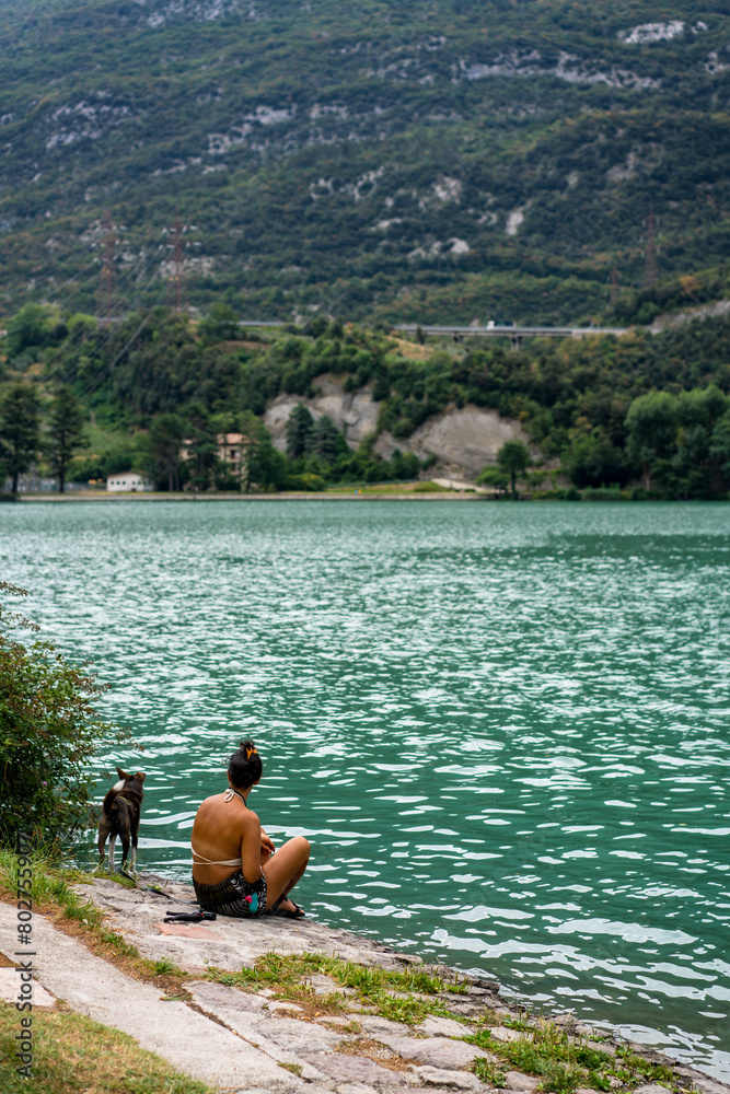 Woman with dog close on a lake