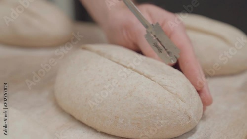 Slow motion video of scoring bread before fermentation with a baker knife