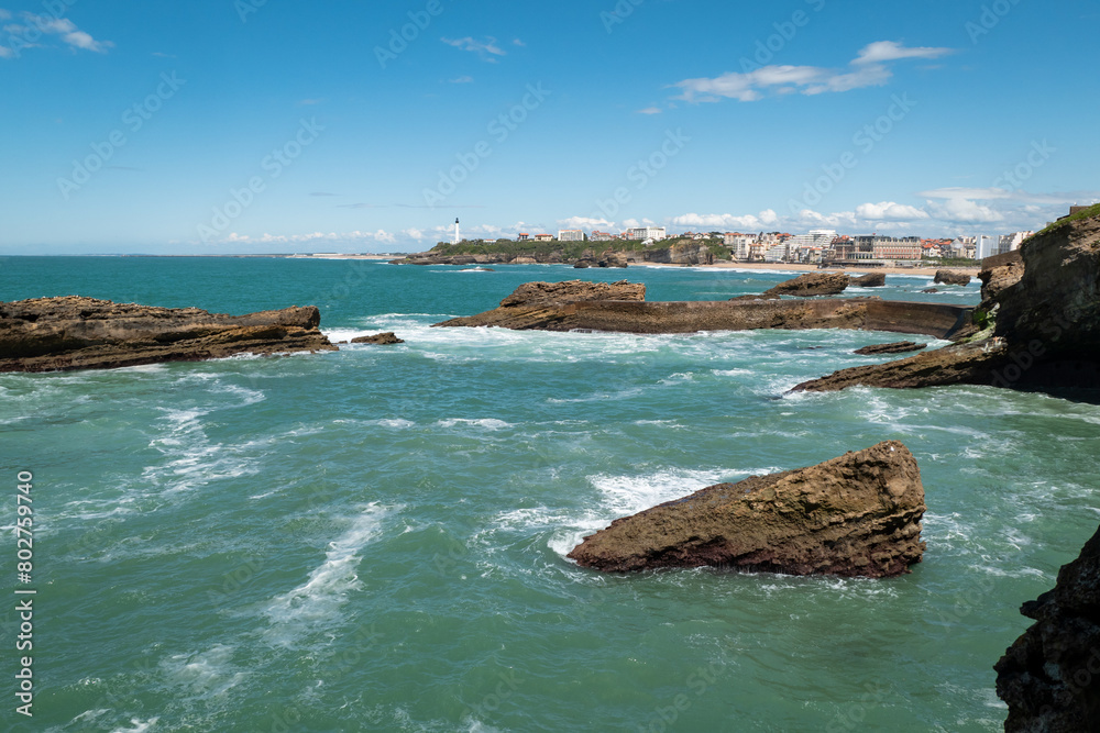 Panorama costeiro: Rochedos na Praia de Biarritz com parte da cidade ao fundo em França