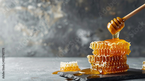 Pouring of sweet honey onto combs on grey background photo