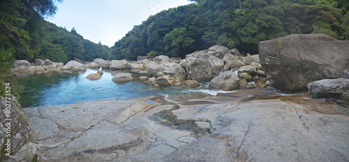 Yakushima nature scenery with Mountain river stone riverbank and small natural pond with big boulders and green forest, Nagata river in Yokogawa Valley photo