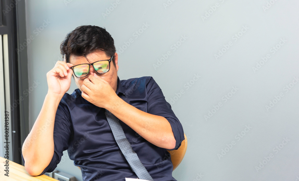 Asian man feeling tired suffering using computer working work place.concept global economic,health problems Asian man feeling tired suffering using computer working work place.concept global economic,health problems