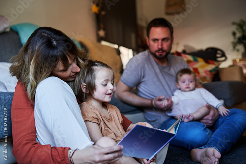 Wallpaper Mural Young family reading storybook together in the living room floor. Torontodigital.ca