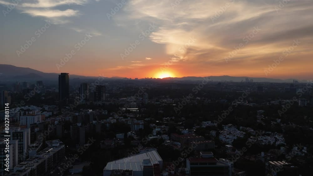 Sunset with the sun setting behind the mountains of Mexico City. Aerial views