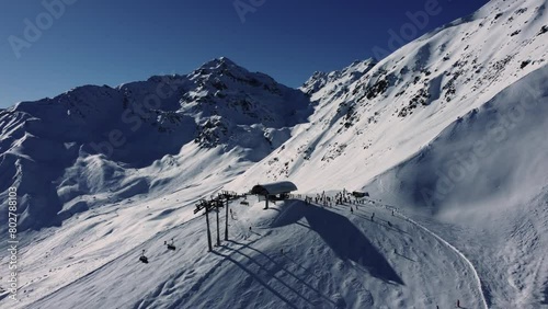 Chair lift station high in Alps during winter sport season, aerial photo