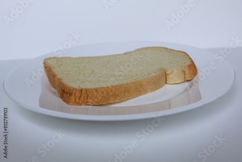 One slice of white bread, on white plate, isolated on white background photo