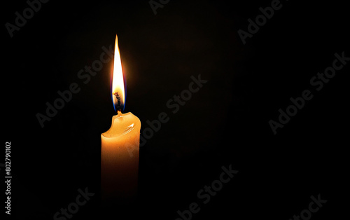 Burning white candle on black background. Close-up photo. With copy space. Image for memory of events and people