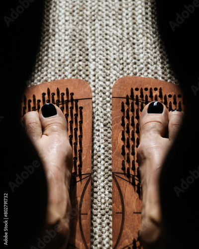 Shadow and light play over wooden acupressure boards with protruding pegs