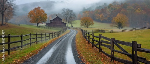 A farm in rural Rockbridge County, Buena Vista, Virginia, with a fence and a foggy fall day, as well as a dirt road driveway on a hill photo