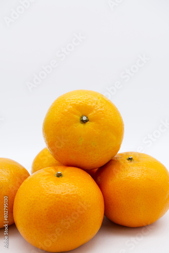 Mandarin oranges stacked together with a white background. Tangerine orange of healthy, organic and fresh fruit. Close-up fresh orange fruit texture with copy space. Still-life fruit with copy space.