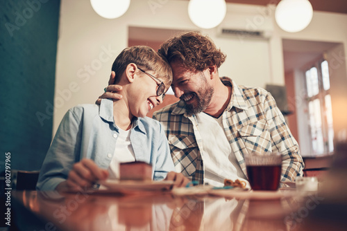 Loving father and his young son laughing and having snacks together while taking a family arts and crafts class at the weekend photo