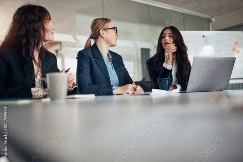 Businesswomen talking during a meeting at a table in an office boardroom photo