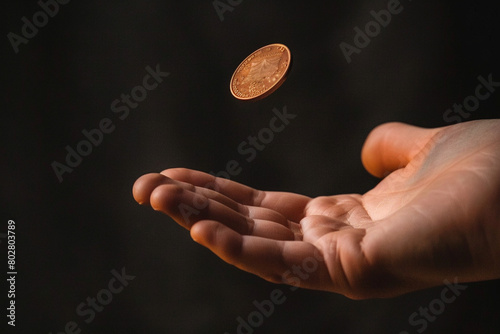 Photo of person's hand tossing a coin. Concept of proper money management  photo