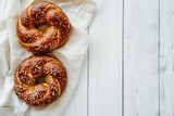 Homemade bavarian pretzels with sesame seeds on white wooden background