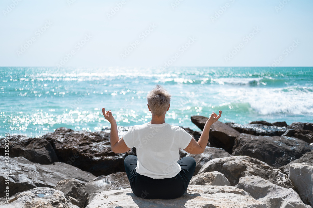 Middle Aged Female Doing Yoga Exercises. Mindfulness Zen Spiritual Meditation Tips. Kundalini Yoga. Reiki Meditation. Relaxing. Unity With Nature. Sea or Ocean Coast Beach Middle Aged Female Doing Yoga Exercises. Mindfulness Zen Spiritual Meditation Tips. Kundalini Yoga. Reiki Meditation. Relaxing. Unity With Nature. Sea or Ocean Coast Beach