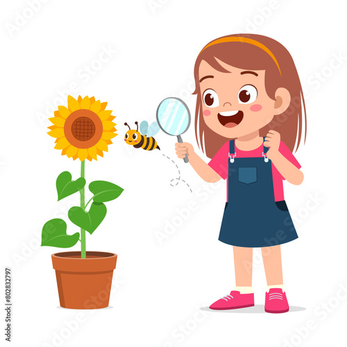 little kid use magnifying glass to observe bee