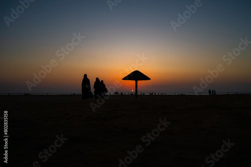Silhouette of people walking on the beach in the evening at Al Seif Beach in Jeddah, Saudi Arabia 