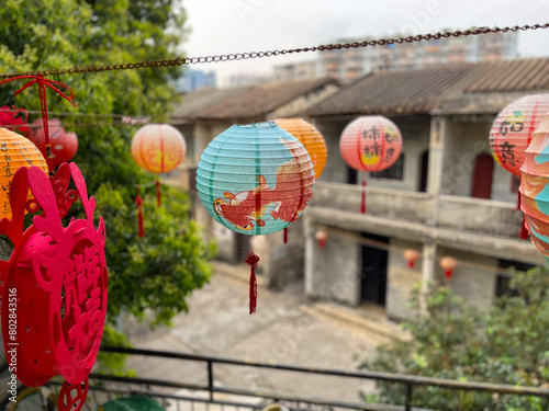 Colourful lanterns in the foreground and old Chinese village houses in the background