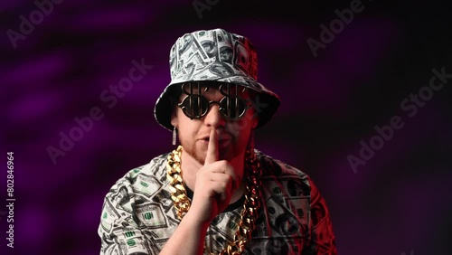 Crazy rich man showing sign of silence and making silence gesture with finger, portrait in studio photo