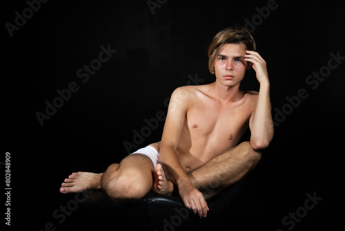 A young attractive guy is resting. Black background.
