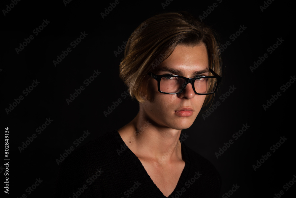 A young attractive guy is resting. Black background. A young attractive guy is resting. Black background.
