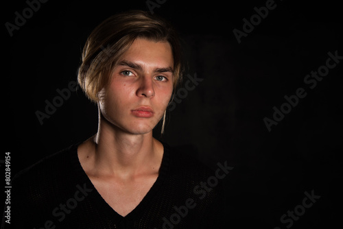 A young attractive guy is resting. Black background.