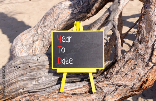 YTD year to date symbol. Concept words YTD year to date on beautiful yellow blackboard. Beautiful old tree background. Business YTD year to date concept. Copy space. photo