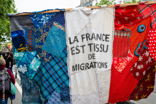 un drapeau aux couleurs de la France avec un slogan pro immigration pendant le défilé du 1er mai à Paris