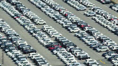 Like gems in a treasure chest, new cars rest gracefully on the ground, as seen from a drone's perspective, promising adventures yet to be taken. Powering progress through mobility. Vehicles concept.
