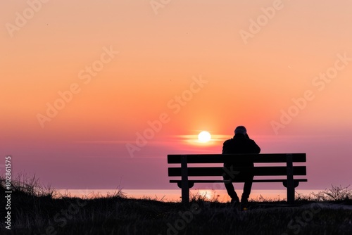 Step into the tranquil silhouette of a lone figure sitting on a bench, watching as the sun sets below the horizon and paints the sky, Generative AI