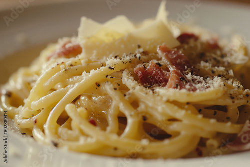 A close-up shot capturing the velvety creaminess of carbonara sauce clinging to perfectly al dente strands of pasta, with delicate shavings of parmesan glistening on top.