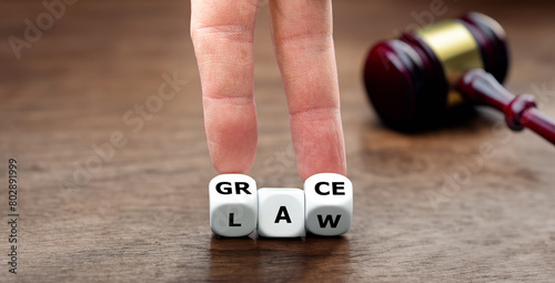 Obraz na płótnie Hand turns dice and changes the word law to grace.