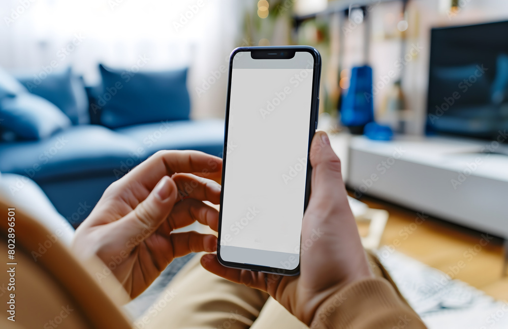 A person sitting on the sofa with their phone in hand, looking at the screen
