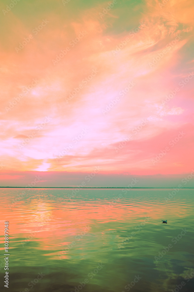 Seascape in the early morning. Calm sea at dawn with beautiful sky. Artistic pink green gradient color