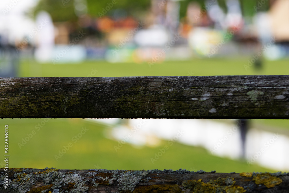 wooden rail fence with green grass and show tents in the background